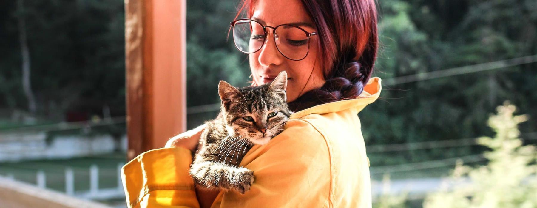 woman holding a cat on a balcony